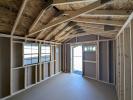 Interior of 10x12 peak shed with two windows on left and double door with transom window to front of shed